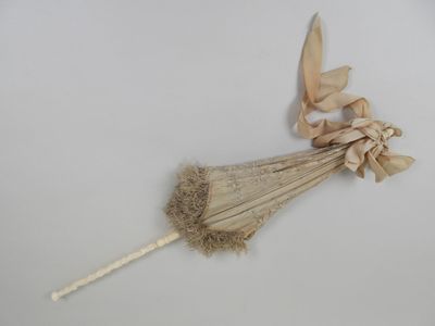 a small umbrella with a bow on it on a white surface