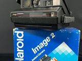 a polaroid camera sitting on top of a blue box