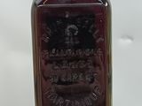an old bottle of liquor sitting on top of a wooden table