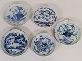 quatre assiettes ornées de motifs bleus et blancs sur un fond blanc