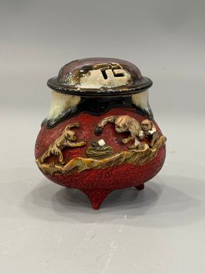 a small red vase with a gold dragon on it