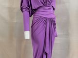 a purple dress on a mannequin stand with a white background