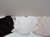 trois vêtements posés sur une table blanche