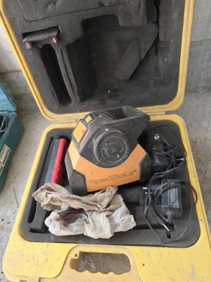 une mallette jaune contenant des outils, posée par terre