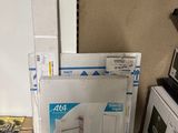 une pile de cartons posée par terre à côté d'un micro-ondes