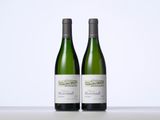 two bottles of wine sitting on top of a table next to each other