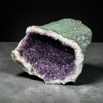 une image représentant un morceau de roche surmonté de cristaux violets