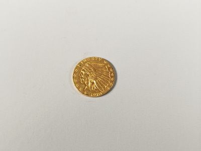 gros plan d'une pièce d'or sur une surface blanche
