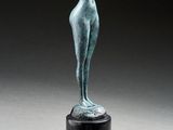 une statue en bronze représentant une femme tenant un oiseau dans la main