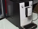 une machine à café en noir et blanc posée sur une table blanche