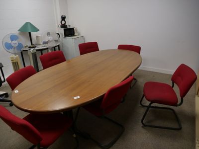 une photo d'une salle de réunion avec une table et des chaises rouges