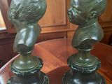 pair of bronze busts of a boy and a girl on a pedestal