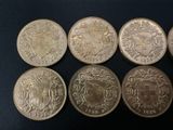 six different british coins are shown in a row on a black surface