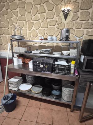 a kitchen with a stove, microwave, dishwasher, and other items on a shelf