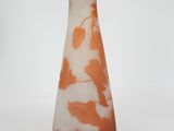 an orange and white vase sitting on a white surface