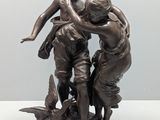 statue représentant trois enfants jouant avec un oiseau, posée sur un socle
