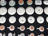 many cups and saucers with numbers on them on a table