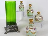 cinq vases et un vase vert posé sur un socle