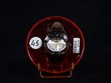 a red watch with a white face on a red stand