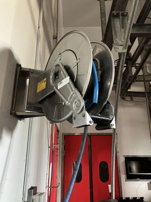 a hose attached to a reel in a garage
