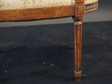 a wooden chair with a beige upholstered cushion on it