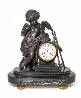 une statue représentant un garçon avec une horloge posée sur une table