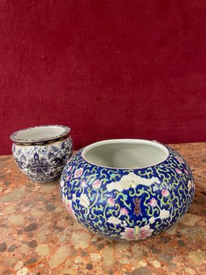 two vases sitting on a table with a red wall in the background