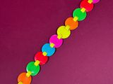 a close up of a colorful bracelet on a purple surface