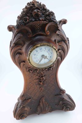 a wooden clock that is sitting on a white surface