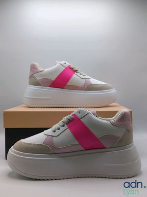 a pair of pink and white sneakers on top of a box
