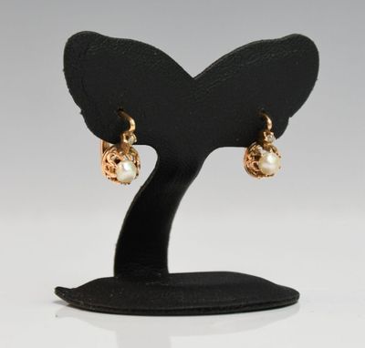 a close up of a pair of earrings on a stand