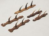six pieces of wood with horns on them on a white surface