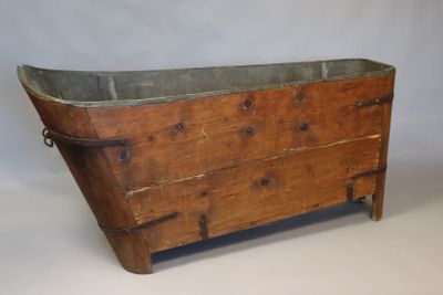 une vieille baignoire en bois munie d'une poignée en métal