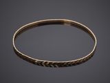 a close up of a gold bang bracelet with a textured design