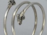 two silver bang bracelets with a fish head on each of them