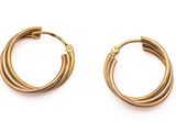 une paire de boucles d'oreilles en or sur fond blanc