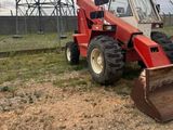 a red tractor that is parked in the dirt
