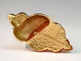 an acorn shaped brooch with a gold finish