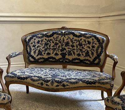 a blue and white couch and two chairs in a room