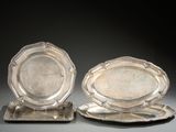 paire de plats argentés sur des socles, sur fond gris