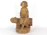 statue représentant un garçon assis sur une bûche avec un chien