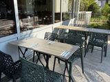 tables and chairs outside of a restaurant with a red umbrella