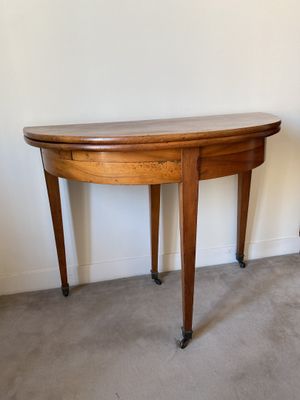 une petite table avec un plateau en bois, montée sur roulettes, dans une pièce