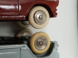 a red toy car on top of a blue toy car on top of a shelf