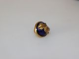a blue and gold ring on a white table