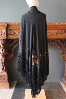 une image d'un châle noir à franges sur une tête de mannequin