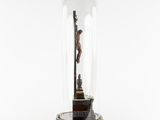 a statue of jesus on the cross under a glass dome