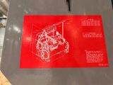 a red sign with a drawing of a machine on it
