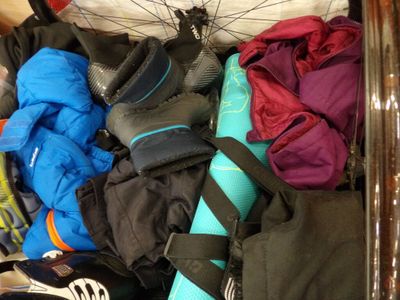 un panier rempli d'équipements de sport et de chaussures posé par terre