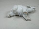 porcelain figurine of a dog laying on its back with a tag on its collar